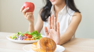 Frau Isst Apfel und Gemüse statt süßem Gebäck