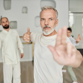 älterer Mann macht Qigong