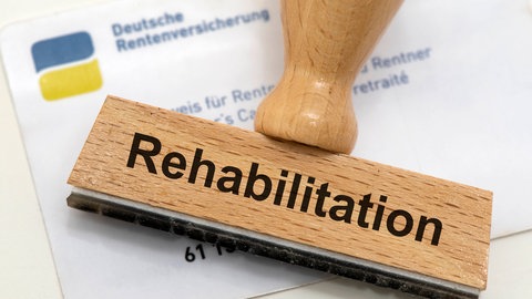 Stempel mit der Aufschrift "Rehabilitation" und ein Ausweis der Deutschen Rentenversicherung