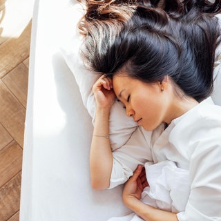 Eine junge Frau liegt im Bett und schläft | Fünf Tipps für einen gesunden Schlaf von Schlafmediziner Dr. Ingo Fietze