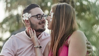 Junges Paar mit Blumen im Haar - Küssen ist gesund | Wie Küssen Glücks- und Kuschelhormone aktiviert 