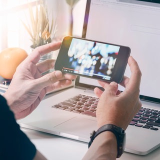 Mann am Smartphone und Laptop