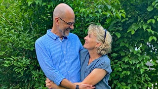 Kris und Frank umarmen sich im Garten. SWR1 Neuanfang: Kris rettet mit einer Organspende ihrem Mann Frank das Leben.