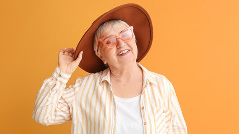 Frau mit Sonnenhut, Sonnenbrille und sommerlicher Kleidung