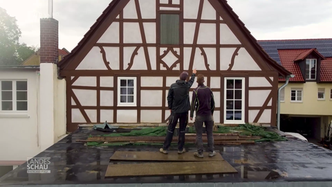 Zwei Brüder begutachten ihr Fachwerkhaus