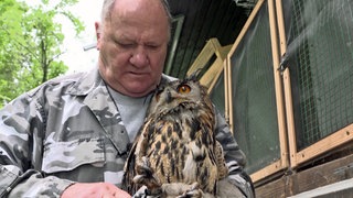 Vogelschützer Kurt Wilhelm mit einem Uhu auf dem Arm