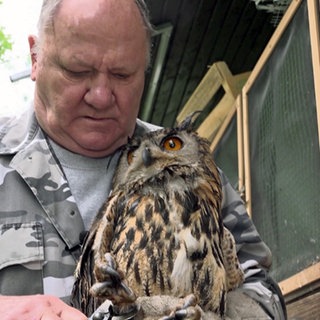 Vogelschützer Kurt Wilhelm mit einem Uhu auf dem Arm