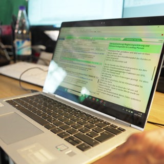 Ein Laptop, auf dem ein Nachrichtenticker zu sehen ist.