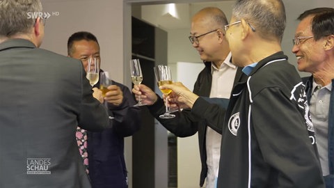 Asiatische und deutsche Alt-Azubis stoßen aufeinander an