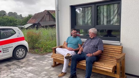 Daniel Müller und Rainer Schwab unterhalten sich auf einer Bank