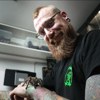 Patrick Meyer mit einer Vogelspinne auf dem Arm