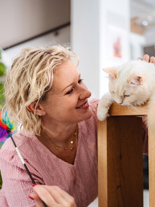 Eine Frau spielt mit einer Katze | Das erlebt ein Katzensitter, wenn die Besitzer im Urlaub sind