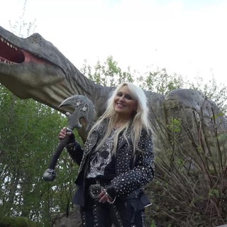Doro Pesch vor einer großen Dinosaurierfigur