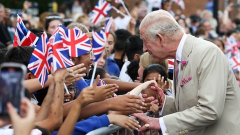 König Charles schüttelt die Hände von vielen jungen Menschen bei seinem Besuch in Newmarket.