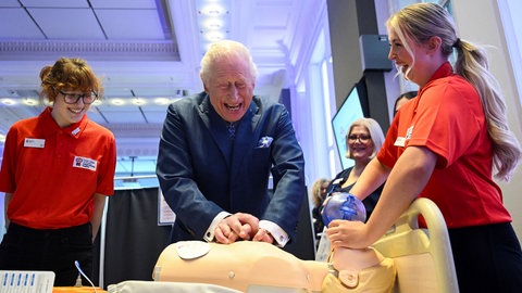 Kleiner royaler Erste-Hilfe-Kurs: Der britische König Charles III. führt eine Herz-Lungen-Wiederbelebung an einer medizinischen Testpuppe durch, als er an einer Feier für den 1.000sten RCN King's Nursing Cadet im Royal College of Nursing in London teilnimmt.