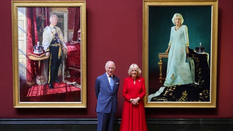 König Charles und Königin Camilla neben ihren Krönungsportraits in der National Gallery in London.