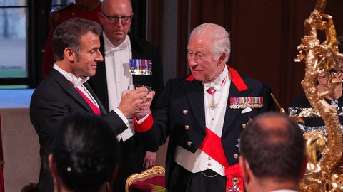 Frankreichs Präsident Emmanuel Macron und König Charles prosten sich beim Staatsbankett zu. 