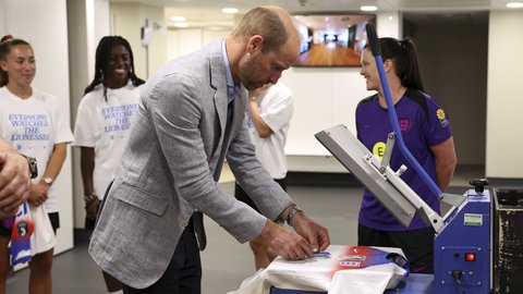 Prinz William druckt eine Rückennummer auf ein Trikot der englischen Fußball-Nationalmannschaft der Frauen..