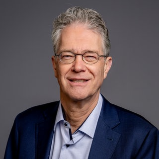 Porträt von SWR4 Experte Christopher Keim in Hemd und dunkelblauem Blazer