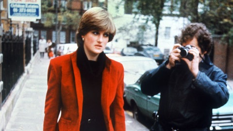 Prinzessin Diana blickt genervt, denn sie wird von einem Journalisten fotografiert