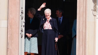 Königin Margrethe steht an ihrem 84. Geburtstag vor Schloss Fredensborg und winkt fröhlich.