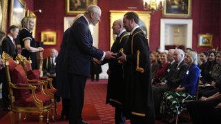 König Charles verleiht den Queen-Elizabeth-Preis für Bildung an Vertreter verschiedener Hochschulen.
