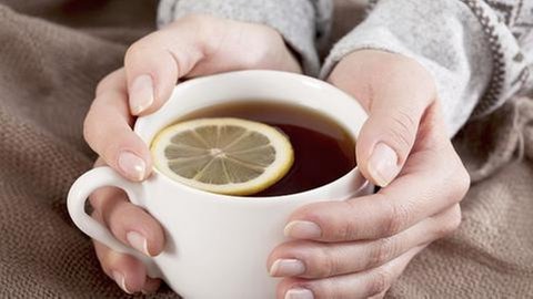 Eine Frau hält eine Tasse Tee