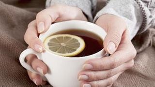 Eine Frau hält eine Tasse Tee