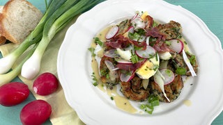 Salat von gebratenen Semmelknödeln mit Radieschen und Gurken