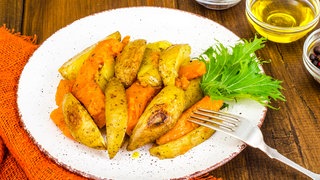 gebackene Kartoffeln und Kürbis auf einem Teller