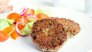 Vegane Burger-Patties auf einem Teller mit Salat
