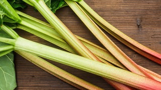 Rhabarber auf einem Holztisch. Für das Gemüse gibt es auch herzhafte Rezepte.