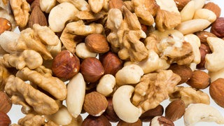 Geschälte Haselnüsse, Walsnüsse, Mandeln und Cashewkerne: Nüsse enthalten viele ungesättigte Fettsäuren und andere gesunde Inhaltsstoffe. Hier ein paar Tipps und Rezepte, wie wir sie beim Backen und Rösten bewahren können.