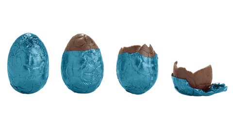 Ein Schokoei, dass immer weniger wird, bis nur noch das blaue Alupapier daliegt