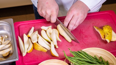 Die Birnen für den Eintopf mit Bohnen und Speck werden geachtelt.