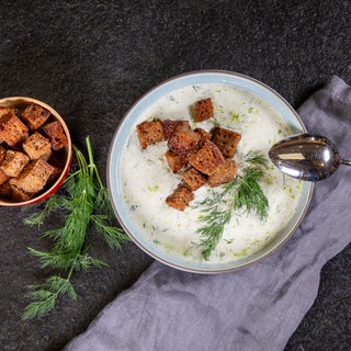 Kalte Gurkensuppe mit Croûtons in einer Suppenschüssel angerichtet