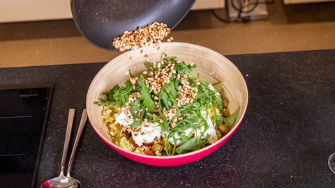 Mediterraner Nudelsalat mit gerösteten Pinienkernen.