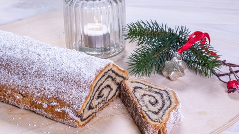Nach dem Backen liegt der fertige Mohnstollen aufgeschnitten auf einem Holzbrett. Bei diesem Rezept müss der Stollen nur ein paar Tage durchziehen.