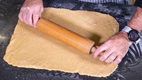 Wie im Rezept beschrieben, wird der Teig für den Mohnstollen auf der Arbeitsplatte ausgerollt. Vor dem Backen wird der Teig in einem weiteren Schritt noch gefüllt.
