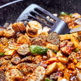 Pilze eignen sich für viele Rezepte: Auf dem Bild werden verschiedene Pilze wie Kräuterseitlinge und Champignons mit Gemüse in der Pfanne gebraten.