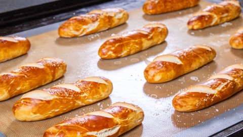 Laugenbrioche liegen auf einem Backblech.