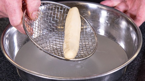 Teig wird in Lauge gegeben.