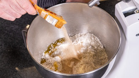 Trockenhefe wird in eine Schüssel mit Mehl gegeben. 