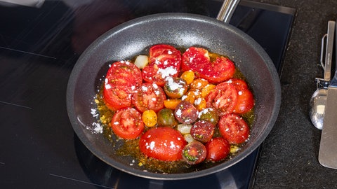 Rezept für geschmelzte Tomaten: Die Tomaten werden mit etwas Puderzucker in der Pfanne karamellisiert.