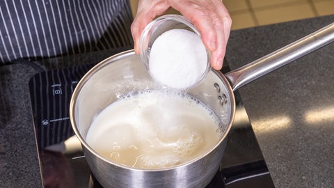 Für die süßen Grießschnitten kocht der Konditor die Milch mit Salz und Zucker auf. 