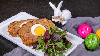 Zwei Scheiben "Falscher Hase" auf einem Teller, mit etwas Salat.