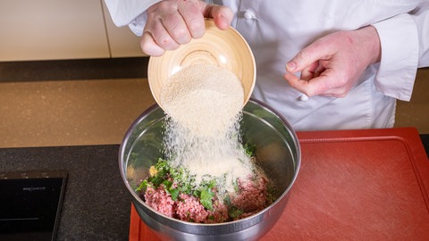 Eine Schüssel mit den Zutaten für den "falschen Hasen", mit Hackfleisch, Senf und Semmelbröseln.
