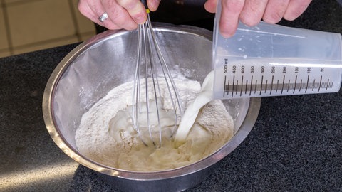 Bei dem Pfitzauf nach original schwäbischem Rezept wird Milch den trockenen Zutaten zugegeben.