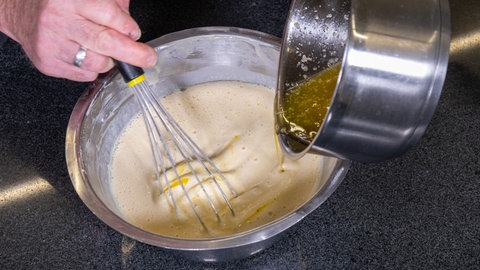 Heiße Butter wird dem flüssigen Pfitzauf-Teig nach original schwäbischem Rezept zugefügt.