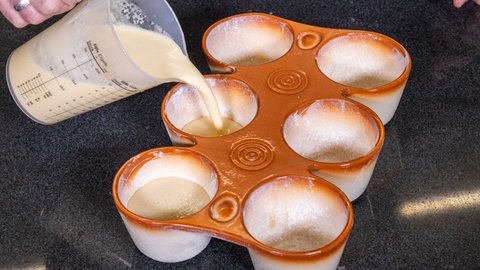 Der flüssige Teig der Pfitzauf nach original schwäbischem Rezept, wird in die Pftzaufform gefüllt.